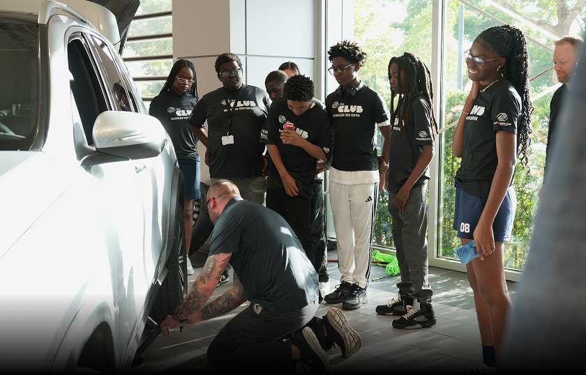Young people learning automotive skills at AutoNation